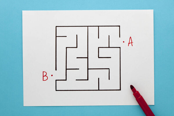 Найти путь в концепции лабиринта на белом листе бумаги на синем фоне
