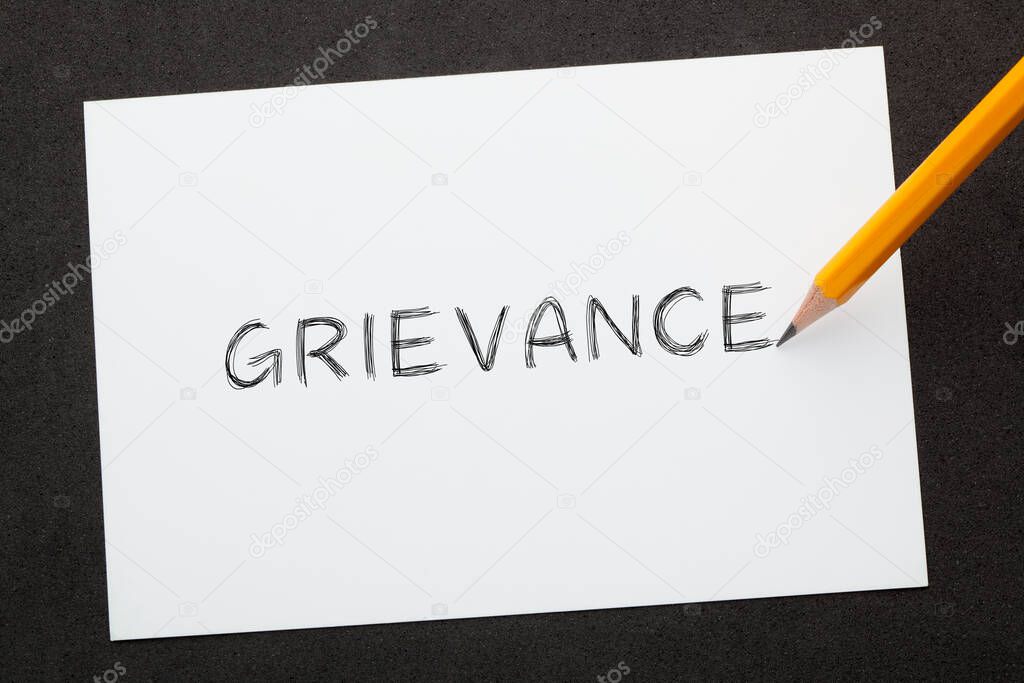 The word grievance written with pencil on  white sheet. Business Concept