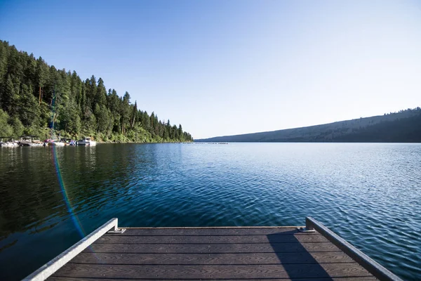 木制码头延伸到平静的高山湖上 — 图库照片