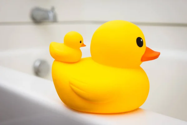Rubber duck family, mother and baby duck on the edge of bath tub