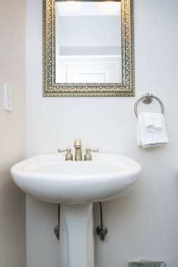 Basit, temiz, beyaz banyo pedastal lavabo ve musluk.