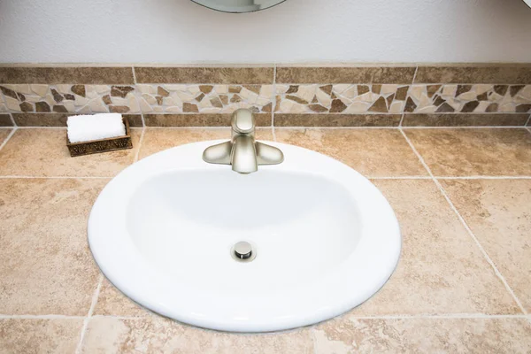Clean white tiled bathroom vanity sink