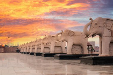 Düz bir çizgiye yerleştirilmiş fil heykelleri.