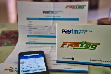 Hızlı Etiket ve masada bir cep telefonu, Paytm ödeme bankası tarafından sağlanan başvuru formu.