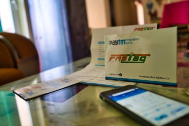 Hızlı Etiket ve masada bir cep telefonu, Paytm ödeme bankası tarafından sağlanan başvuru formu.