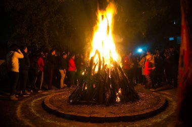 Etrafı insanlarla çevrili Lohri festivali için büyük bir ateş yakıldı.