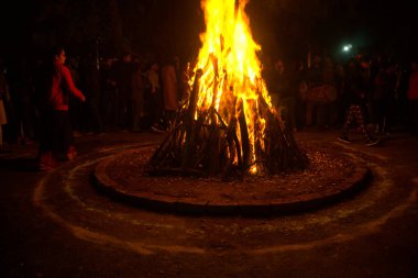 Etrafı insanlarla çevrili Lohri festivali için büyük bir ateş yakıldı.
