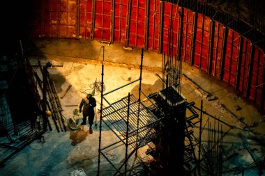 Hindistan 'da inşaat işçileri inşaat alanında tırmanıyor ve inşaat demirleme platformu inşa ediyorlar.