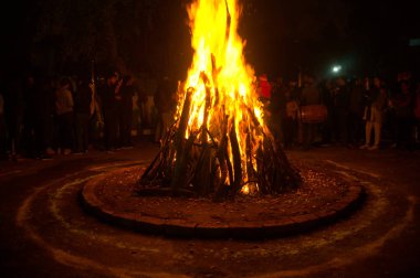 Etrafı insanlarla çevrili Lohri festivali için büyük bir ateş yakıldı.