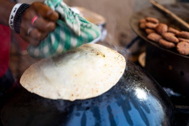 Adam Hindistan ve Pakistan 'dan getirilmiş Babür mutfağında ulta tawa paratha ekmeği yapıyor.