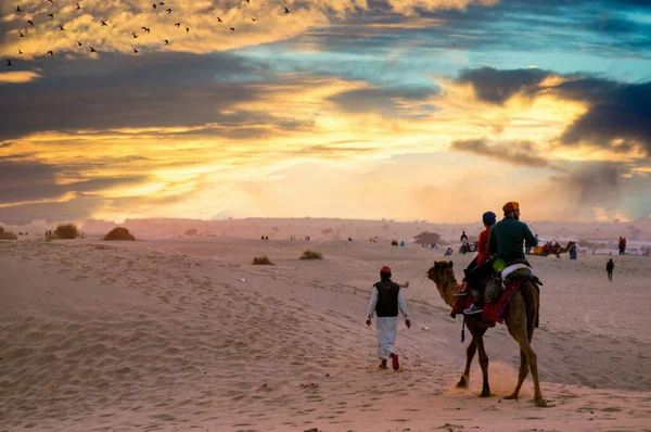 Un camello con dos jinetes al atardecer — Foto de Stock