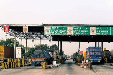Hindistan otoyolundaki boş gişe. Yatak başlığında FASTag çağrısı ve trafik bekliyor.