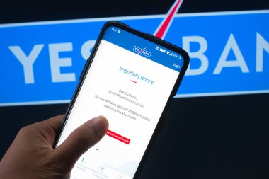 Evet banka yönetim kurulunun önündeki evet bankasının mobil uygulamasına bağlanmış bir cep telefonu