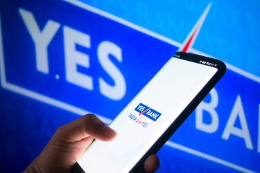 Evet banka yönetim kurulunun önündeki evet bankasının mobil uygulamasına bağlanmış bir cep telefonu