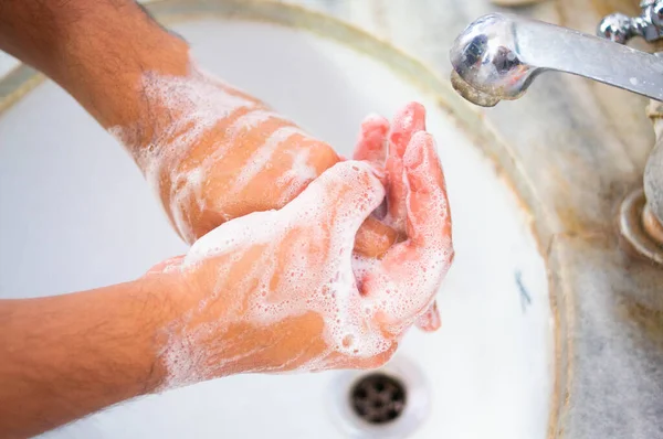 Indiër die handen wast in een wit gekleurde gootsteen — Stockfoto