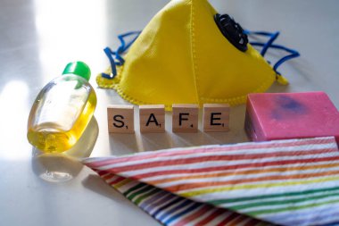 Tahta bloklu düz tabaka, güvenli yazım, sarı yüz maskesi, dezenfektan ve coronavirüs güvenliği için sabun.