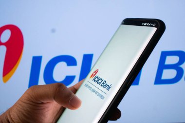 Jaipur, Hindistan, Circa 2020 - ICICI bankasının mobil uygulamasına ICICI banka yönetim kurulu önünde giriş yapan bir cep telefonu. Arka plan parlak bir şekilde ışıklandırılmış. Ekran mobil uygulamanın oturumunu gösterir.