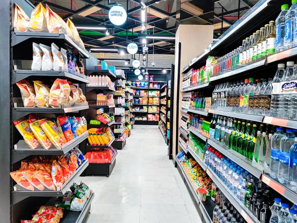 Shot of shelves of retali store filled with bottled water and snack items like chips and treats from some of the top brands in India — Stock Photo, Image