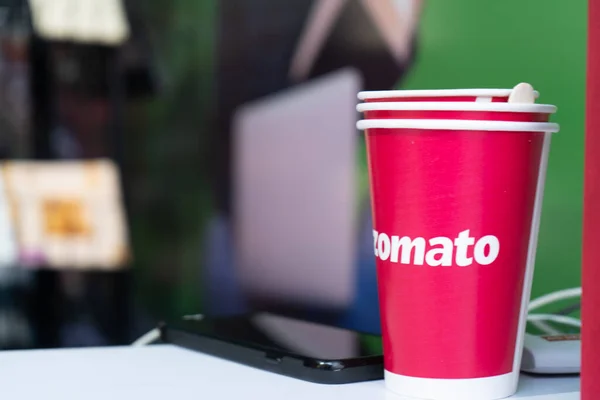 Red disposable cups with zomato logo on them stacked for use at an event — Stock Photo, Image