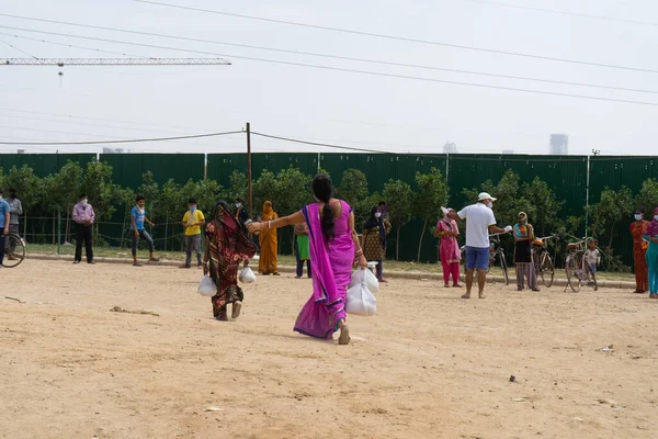 グルガオン デリー インド 2020年頃 毎日の労働者 労働者 メイド ドライバー ヘルパー 清掃員などへの寄付ドライブ中に彼らに与えられた食糧配給を運ぶ種の恵まれない女性 — ストック写真