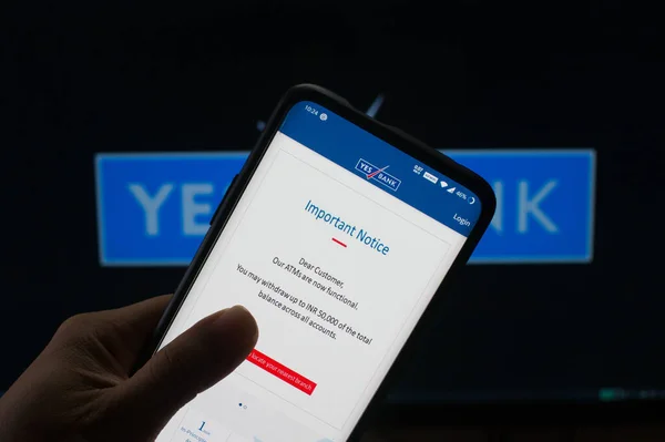 Κινητό που συνδέεται με την εφαρμογή yes bank mobile μπροστά από το yes bank board — Φωτογραφία Αρχείου