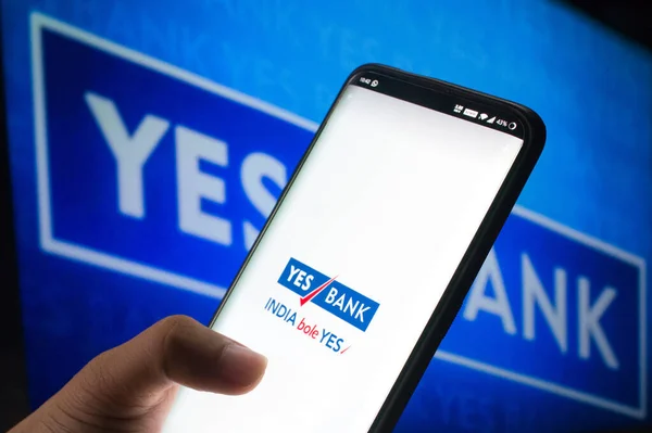 Κινητό που συνδέεται με την εφαρμογή yes bank mobile μπροστά από το yes bank board — Φωτογραφία Αρχείου