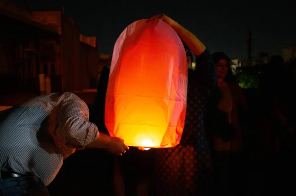 Les gens tenant une lanterne rouge avec les flammes montrant clairement — Photo