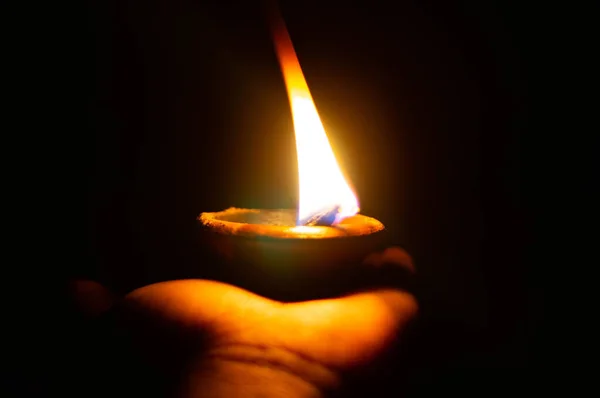Lit diya lub lampa gliniana na dłoni osoby — Zdjęcie stockowe