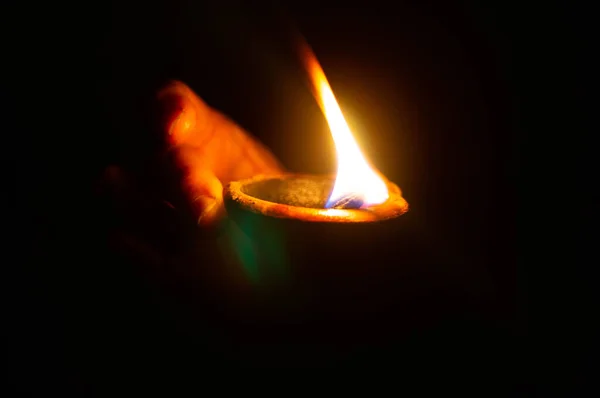 Lit diya lub lampa gliniana na dłoni osoby — Zdjęcie stockowe