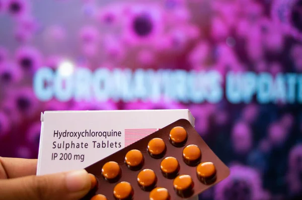Hydroxychloroquine Sulphate tablets with coronavirus written in background — Stock Photo, Image