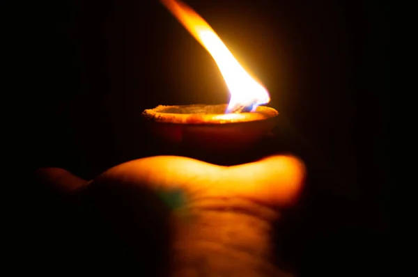 Lit diya or clay lamp on the lalm of a person — стоковое фото