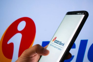 Jaipur, Hindistan, Circa 2020 - ICICI bankasının mobil uygulamasına ICICI banka yönetim kurulu önünde giriş yapan bir cep telefonu. Arka plan parlak bir şekilde ışıklandırılmış. Ekran mobil uygulamanın oturumunu gösterir.
