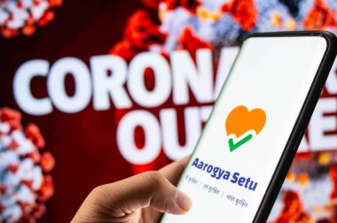 Jaipur, India , Circa 2020 - Aarogya Setu app, an app developed by government of India to track the Covid-19 status, logged in on a mobile infront of a red screen. clipart