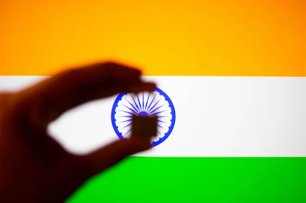 Photographs of the indian flag with orange, white and green colours with a hand holding a lock in front of it to symbolize the lockdown in the country