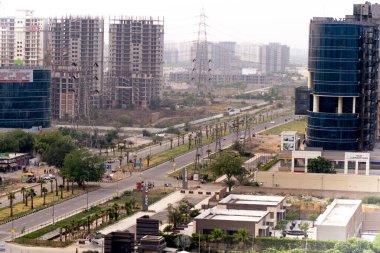 Çekimler boş sokakları ve kavşağı gösteriyor. Gökdelenlere taşınıyor. Yerleşim yerleri, evler, ofisler ve daha fazlası modern gurgaon şehrinde.