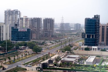 shot showing the empty streets and intersection moving to sky scrapers with resedences, homes, offices and more in the modern city of gurgaon clipart