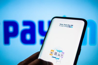 Paytm uygulaması Paytm yazılı beyaz ekranın önündeki cep telefonundan bağlandı