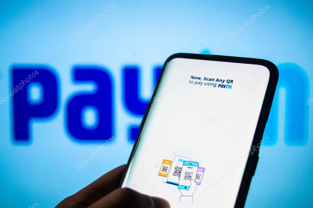 Jaipur, India , Circa 2020 - Paytm app home screen logged in on a mobile phone with paytm written on a whit board in the background