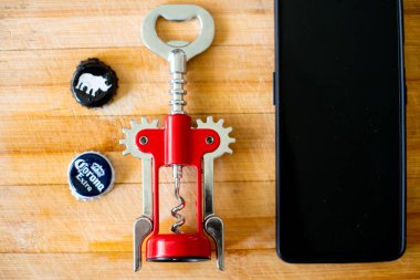 Cep telefonu, şişe açacağı ve bira şişesi kapakları ve beyaz gergedan ile tahta tahta bir shot.