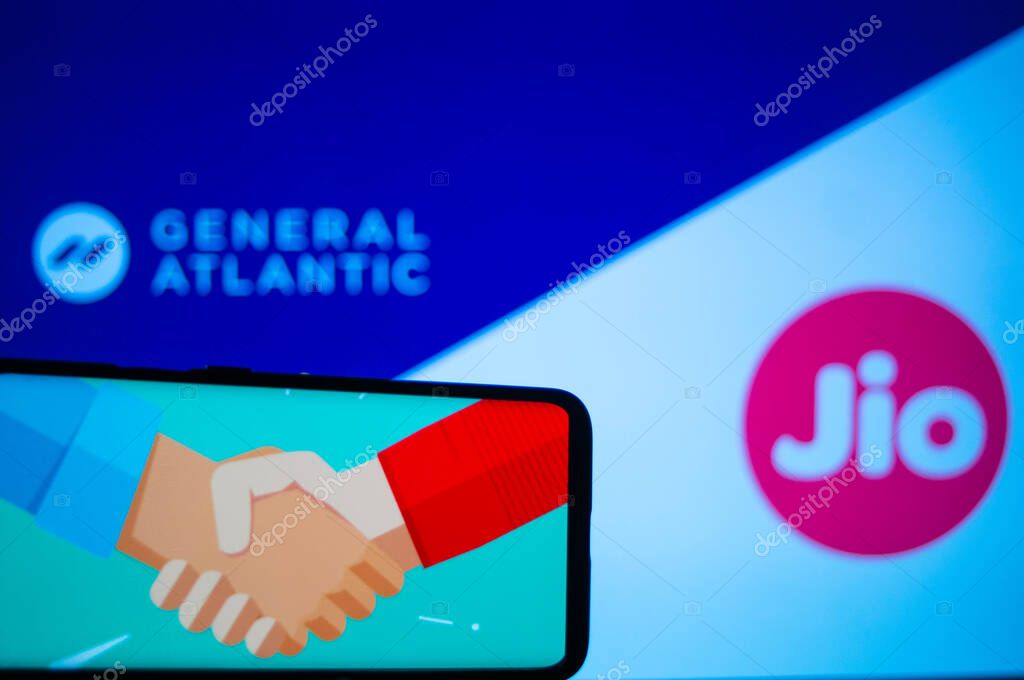 Jaipur, India, Circa 2020 - Photograph of a mobile phone with a handshake, signifying a deal, with general atlantic and Reliance jio in the background