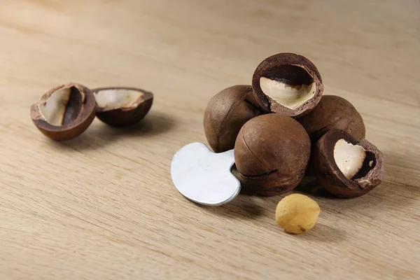 Nueces Macadamia Una Llave Para Abrirlas Sobre Una Mesa Roble — Foto de Stock