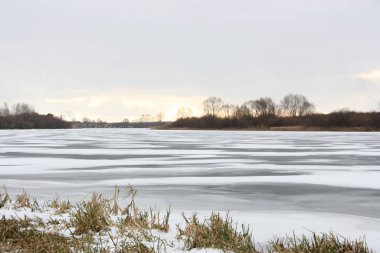 Gün batımında nehrin buzunda kar.