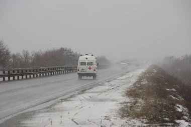 Ambulance car on a winter road in inclement weather
