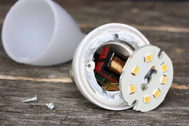 Karanlık bir masanın üzerindeki Led ampulünün bileşenleri