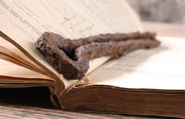 Eski bir kitabın sayfaları arasındaki paslı metal detayı