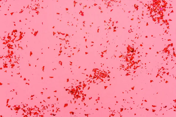 Foto de cor vermelha abstrato confete brilho polvilha no fundo da moda rosa. Fundo festivo de férias para seus projetos. Conceito de celebração. Padrão de Natal. Vista superior, flat lay — Fotografia de Stock