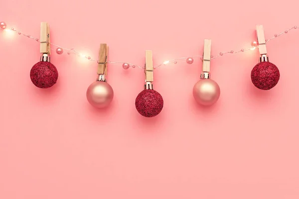 Noel kompozisyonu, moda renkler. Pembe arka planda pembe ve kırmızı parlak toplardan yapılmış çelenkler. Noel, kış, yeni yıl konsepti. Düz konum, üst görünüm, kopyalama alanı