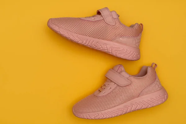 Sapatos esportivos rosa no fundo amarelo. Novos tênis em fundo pastel amarelo. Perder peso e conceito de esporte. Vista superior, flat lay, espaço de cópia — Fotografia de Stock