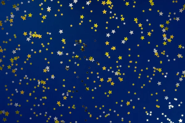 Κλασικό μπλε αφηρημένο φόντο. Εορταστικό φόντο διακοπών για τα έργα σας. Χρώμα της έννοιας του έτους 2020. Φωτογραφία από κομφετί χρυσά και ασημένια αστέρια λάμπει σε μπλε φόντο. Πάνω άποψη, επίπεδη lay — Φωτογραφία Αρχείου