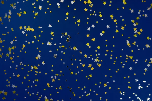 Fundo abstrato azul clássico. Fundo festivo de férias para seus projetos. Cor do ano 2020 conceito. Foto de confete ouro amd estrelas de prata brilha no fundo azul. Vista superior, flat lay — Fotografia de Stock